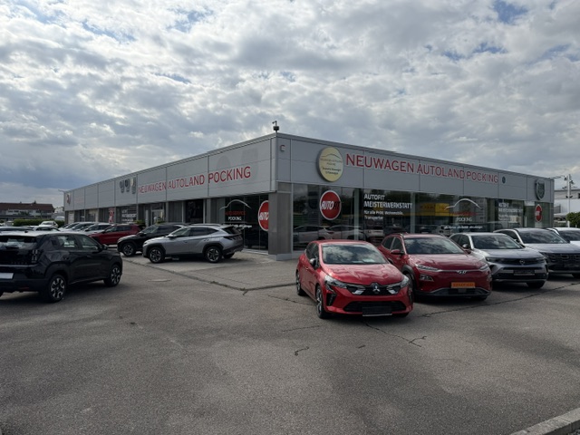 Das Autohaus von draußen fotografiert. Es stehen Autos davor